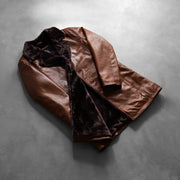 Styled Fit Perspective of Men's Cinnamon Distressed Leather Fur Nahkatakki Pitkä Miehille on Model - Natural Daylight Drape