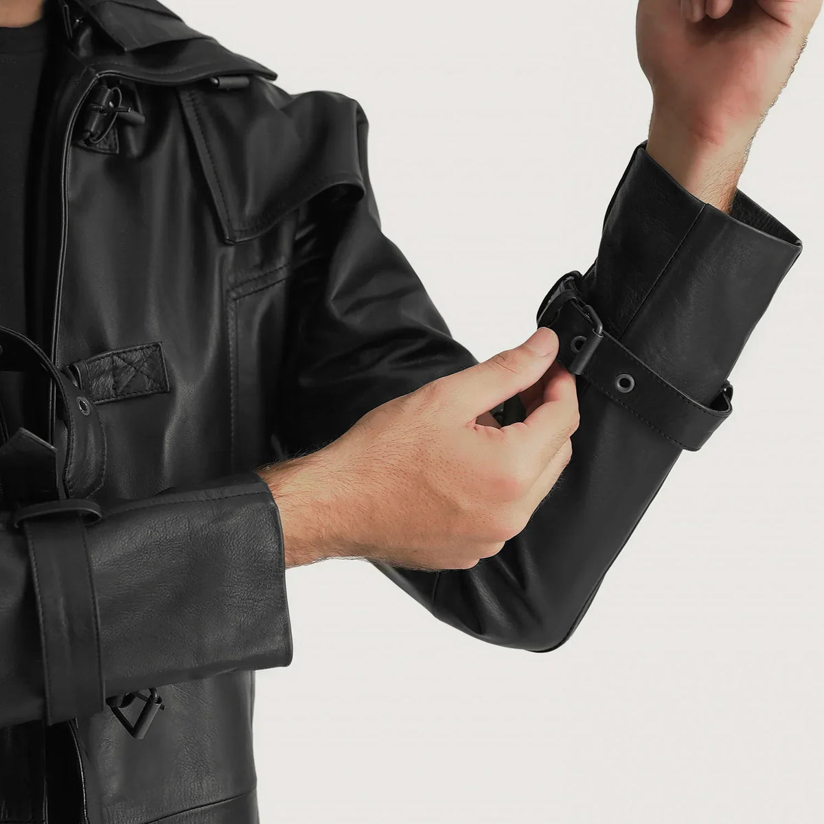 
Yksityiskohtainen lähikuva of Shirt collar with a large hood & Belted Hardware on Huntsman Musta Hooded Nahkainen Trenssitakki Miehille