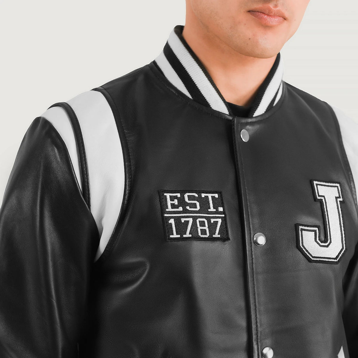 
Yksityiskohtainen lähikuva of Varsity & Snap Button Hardware on Liberte New Jersey Musta Leather Varsity Nahkatakki Miehille